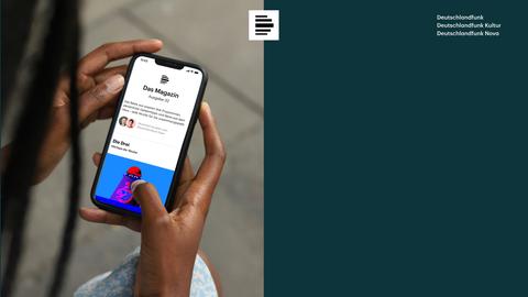 Eine weibliche Hand mit einem Smartphone, auf dem der Magazin Newsletter des Deutschlandfunk angezeigt wird