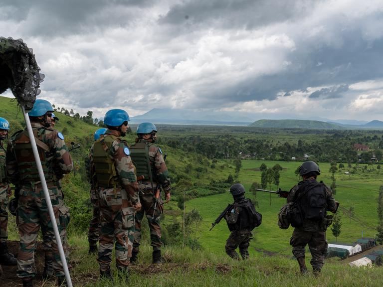 Blauhemsoldaten stehen während einer Übung bewaffnet auf einem Hügel im Kongo.