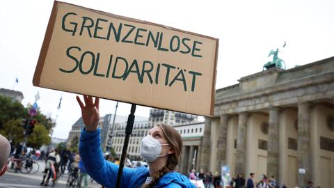 Demonstration in Berlin im September 2021: Eine Frau hält ein Plakat hoch auf dem "Grenzenlose Solidarität" steht. 