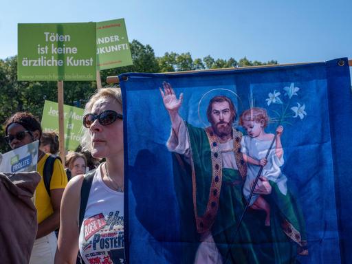 Mehrere Hundert Abtreibungsgegner demonstrieren am Samstag (16.09.2023) im Zentrum Berlins für einen unbedingten Lebensschutz. Eine Frau hält ein Transparent mit Jesus und einem Kind darauf.