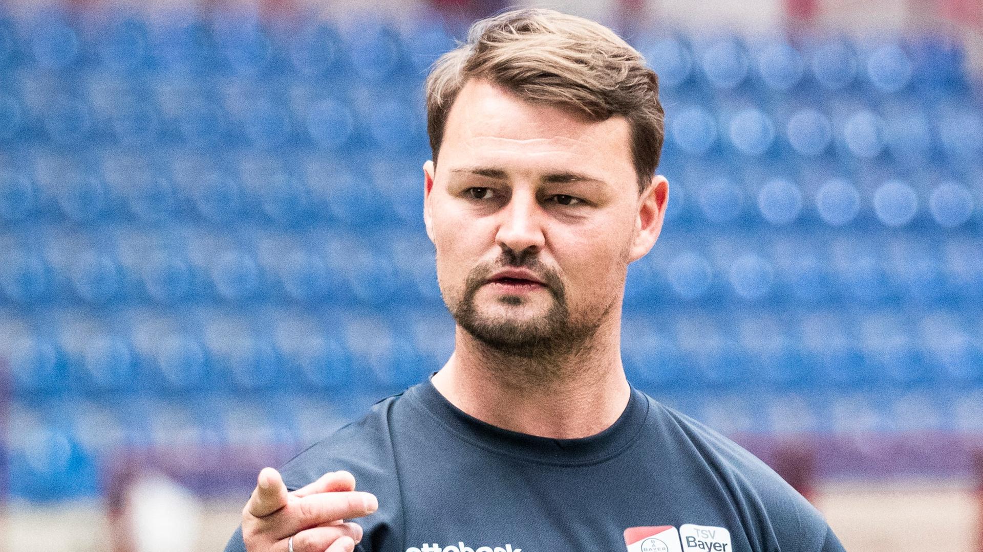 Ein Mann steht in einem Stadion. Ein Mann steht in einem Stadion.