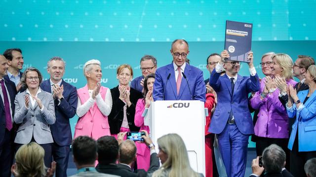 Friedrich Merz steht gemeinsam mit Deligierten auf der Bühne des CDU-Parteitages.