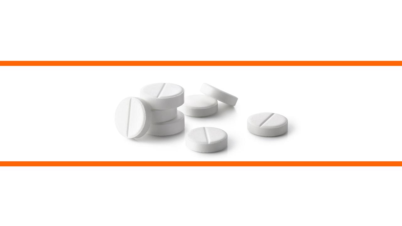 Schwarz-weißes Bild von Paracetamol Pillen vor weißem Hintergrund im mittleren Drittel des Bildes. Die beiden weißen Bilddrittel oben und unten sind mit orangenen Streifen abgetrennt.