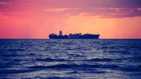 Ein Schiff fährt während der Dämmerung auf dem Meer