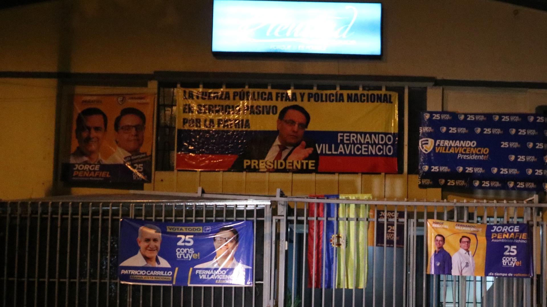 Nächtliches Bild des Tatort vor einer Schule, in der der Präsidentschaftskandidat Fernando Villavicencio während einer Wahlkampfveranstaltung in Quito, Ecuador, erschossen wurde. Wahlplakate säumen die Zäune und das Gebäude. Nächtliches Bild des Tatort vor einer Schule, in der der Präsidentschaftskandidat Fernando Villavicencio während einer Wahlkampfveranstaltung in Quito, Ecuador, erschossen wurde. Wahlplakate säumen die Zäune und das Gebäude.