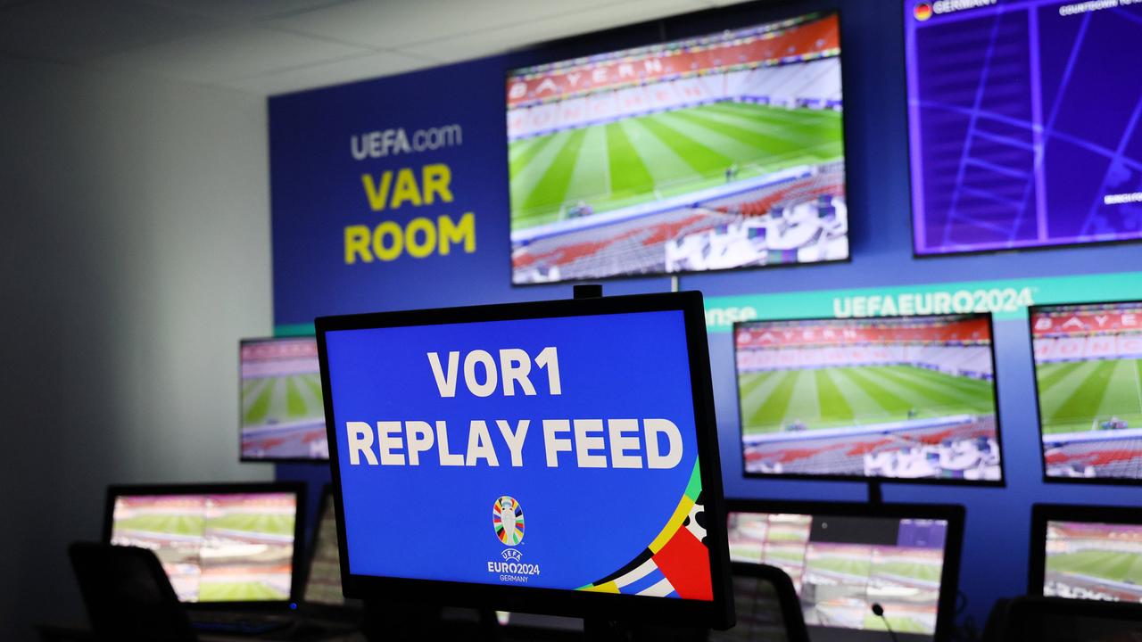 Zu sehen sind zahlreichen Bildschirme, die unter anderem Szenen eines Fußball-Spiels zeigen.