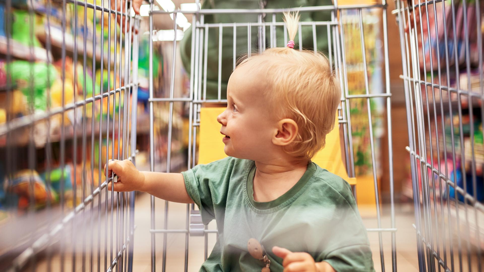 Ein Baby sitzt im Einkaufswagen.