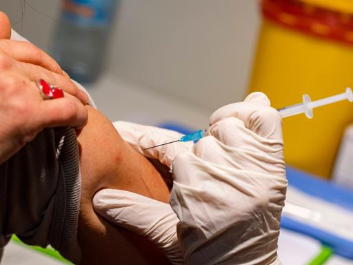 Eine Frau bekommt die eine mRNA-Coronaimpfung in den Oberarm.