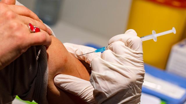 Eine Frau bekommt eine Impfung in den Oberarm.