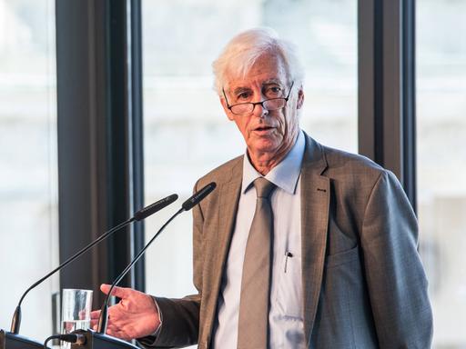 Moshe Zimmermann spricht auf einem Podium.