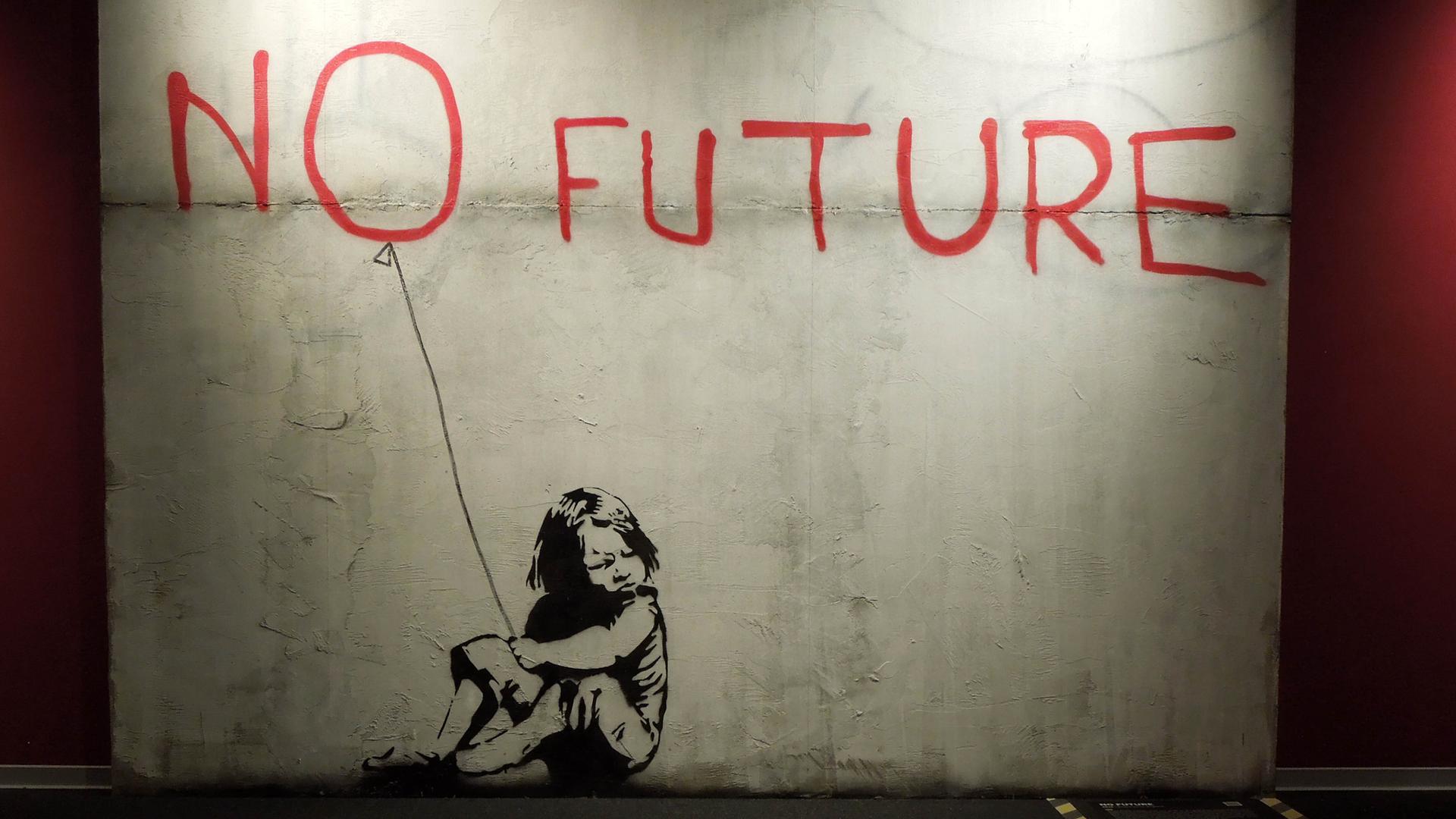 An eine Betonwand ist in schwarz die Silhouette eines Mädchens gezeichnet. In Rot steht darüber "No Future", sodass das O wie ein Luftballon über dem Mädchen schwebt.