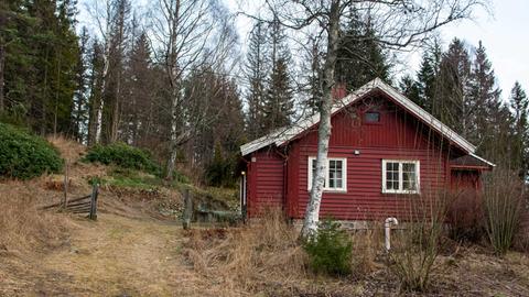 Ein rotes Haus am Waldrand in Norwegen.