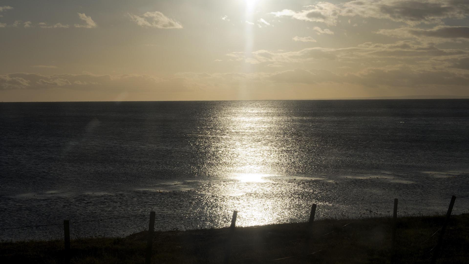 Sonnenaufgang über dem Meer an der Magellanstraße in Punta Arenas, Chile