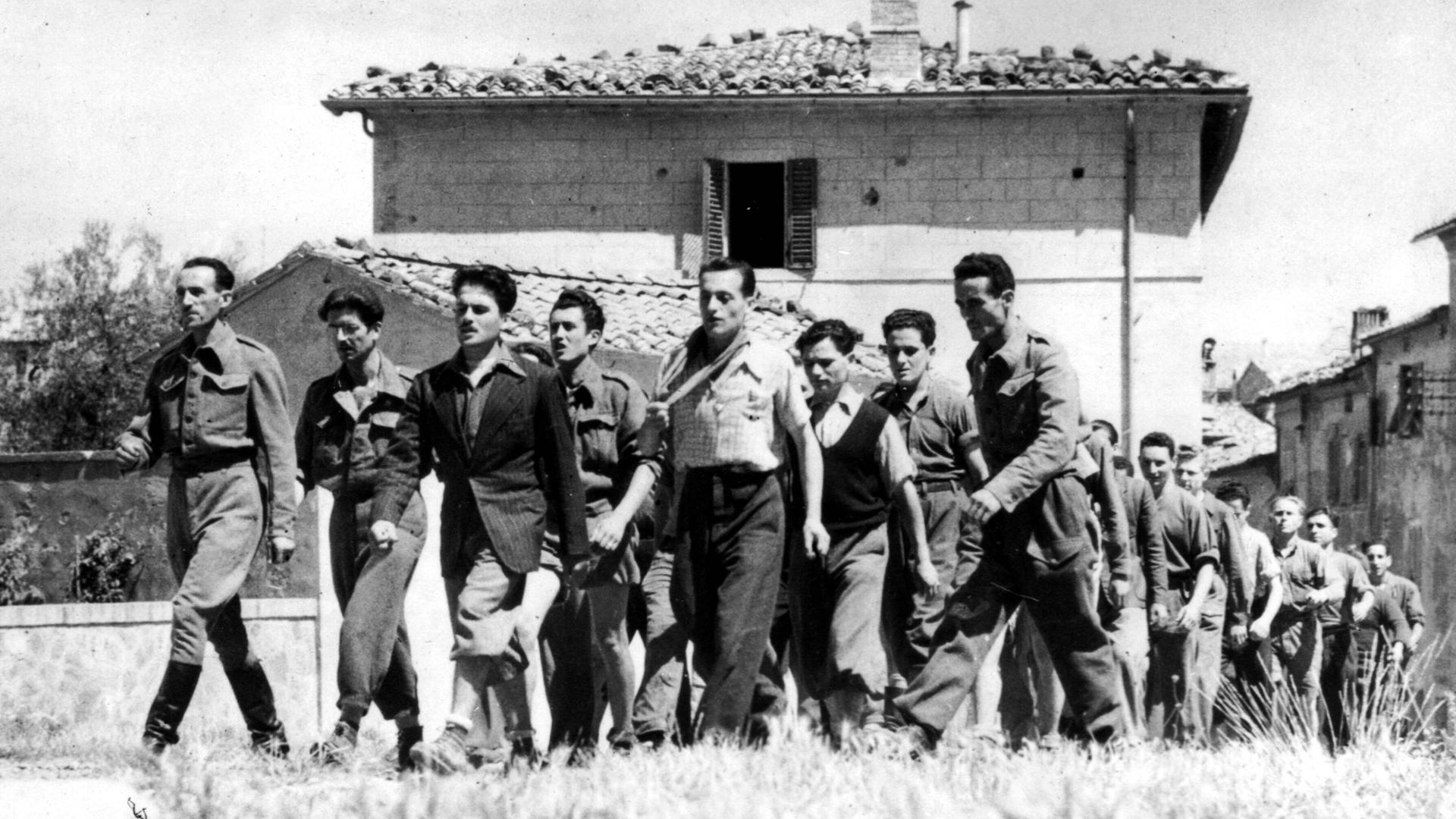 Italienische Partisanen marschieren durch die Stadt Montalcino in Italien im Sommer 1944.