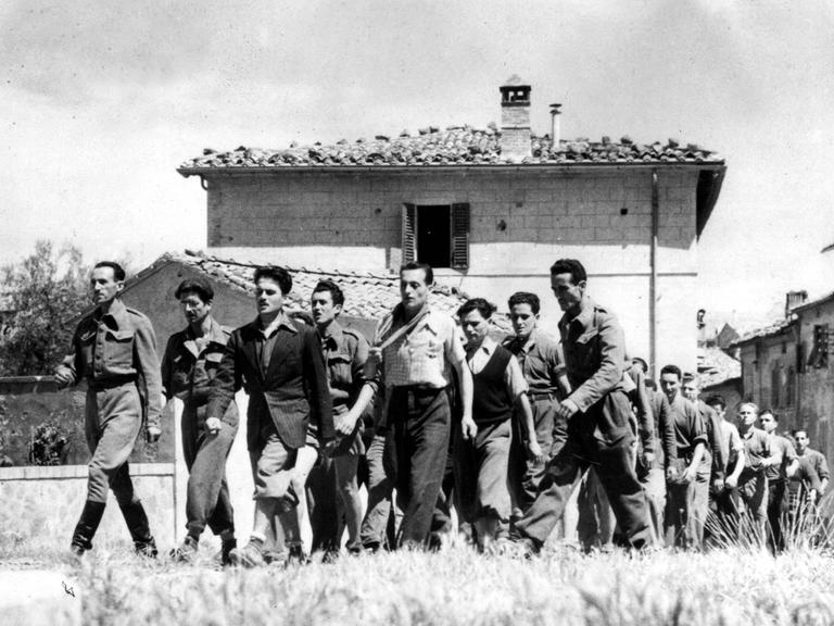 Italienische Partisanen marschieren durch die Stadt Montalcino in Italien im Sommer 1944.