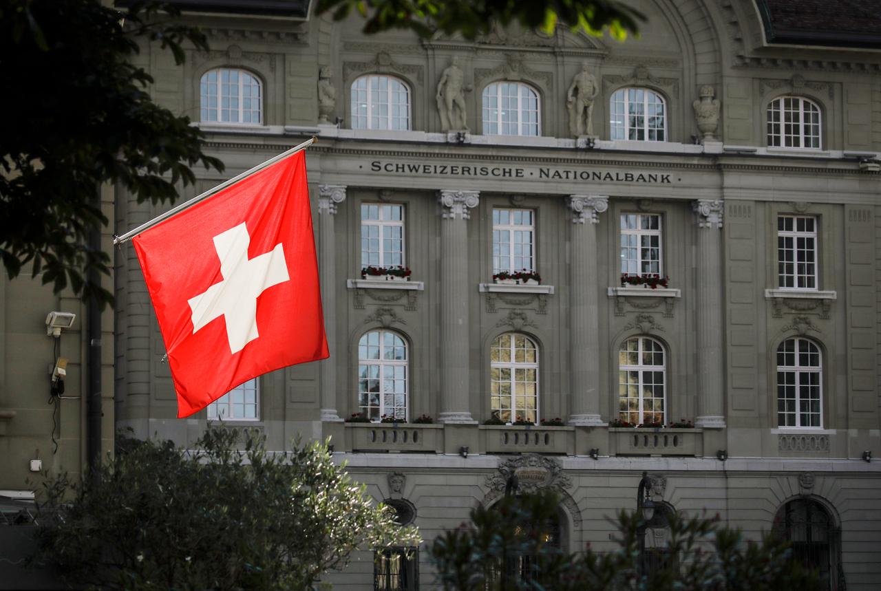 Die schweizer Nationalflagge weht vor dem Gebäude der Schweizer Nationalbank in Bern.