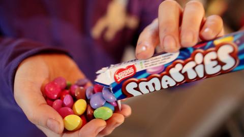 Ein Kind schüttet sich Smarties in die Hand.
