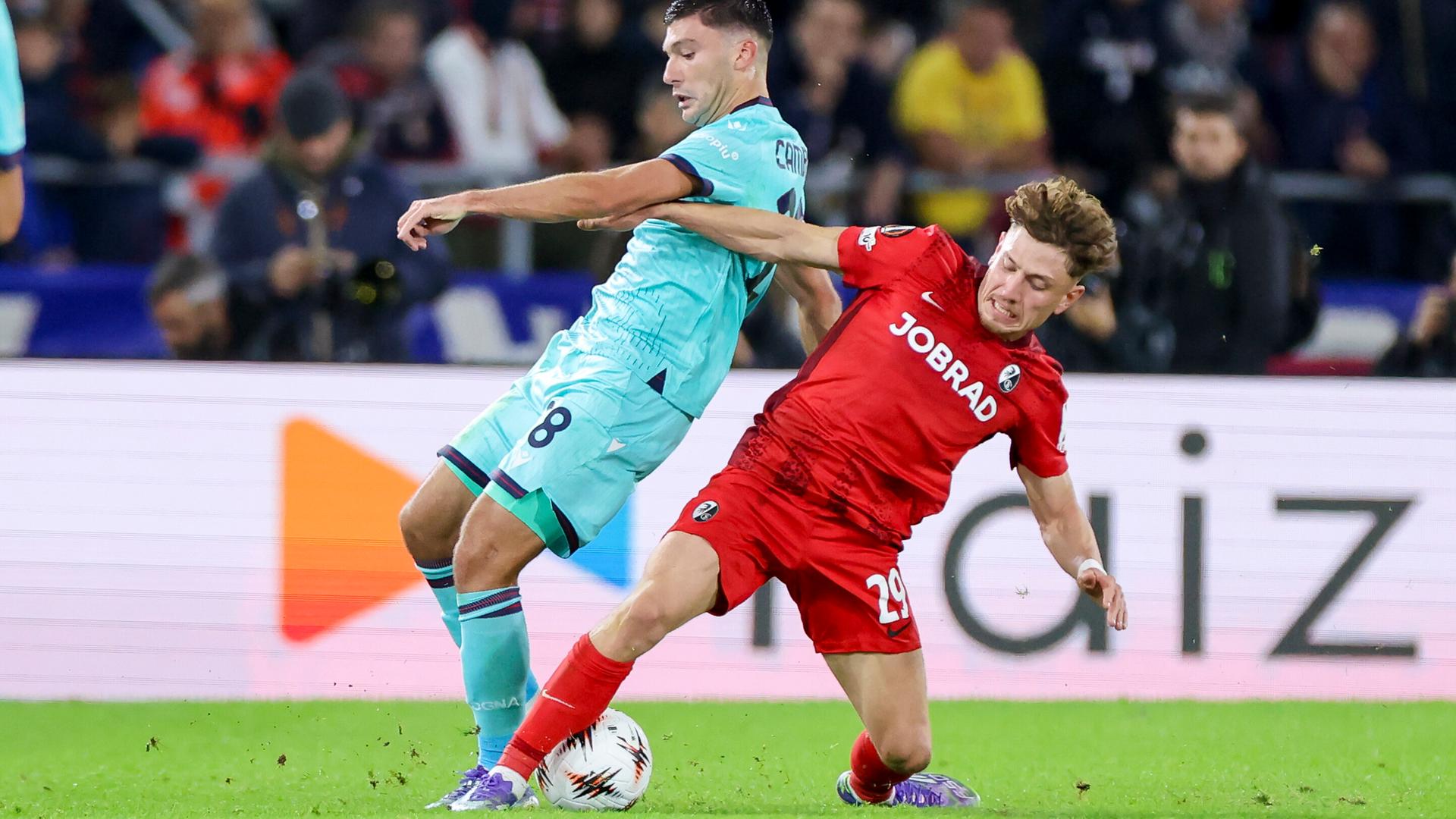 Philipp Treu im roten Trikot und Remo Freuler im hellblauen Trikot kämpfen um den Ball.