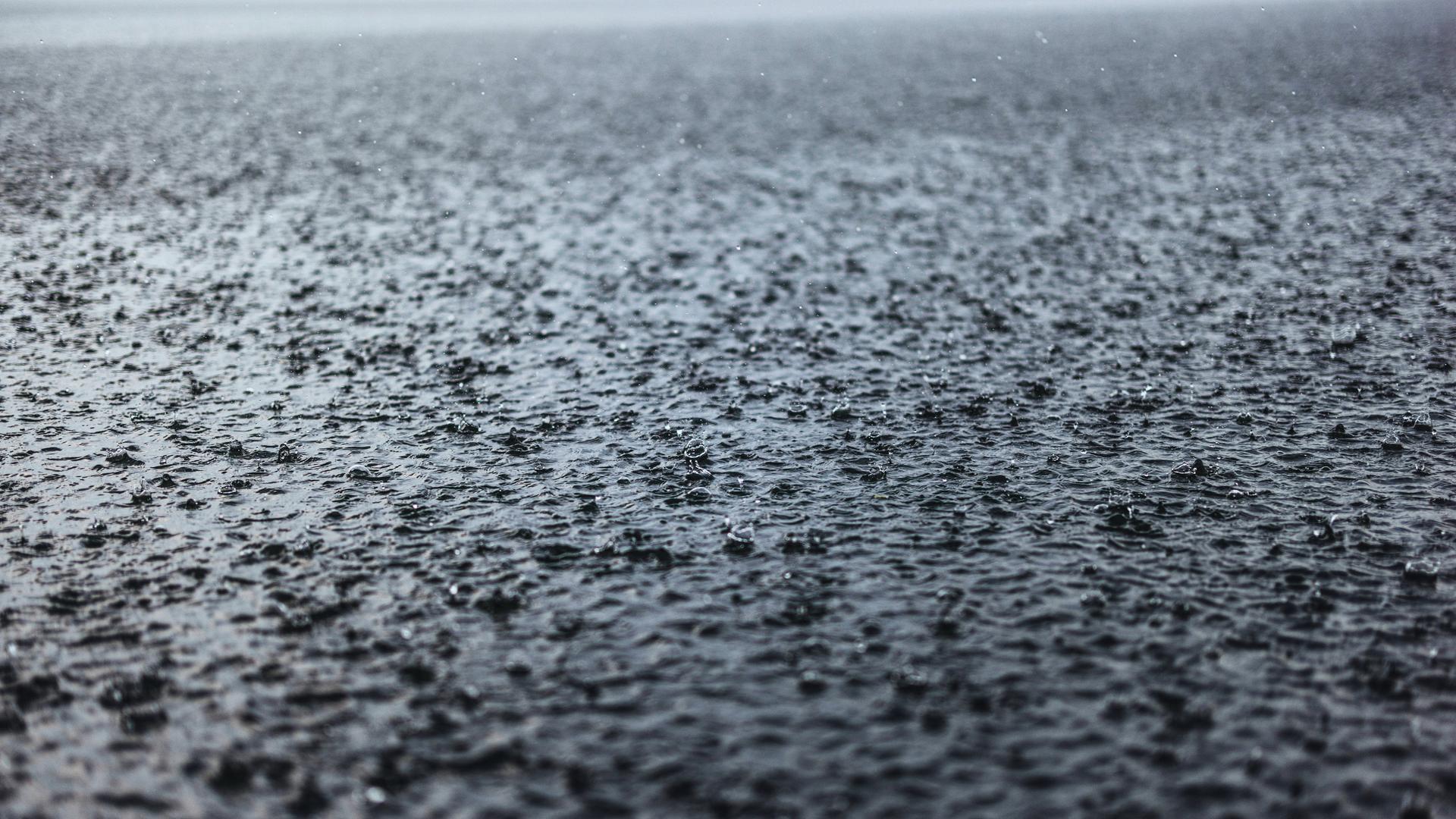 Starker Regen fällt auf die Oberfläche eines Sees.