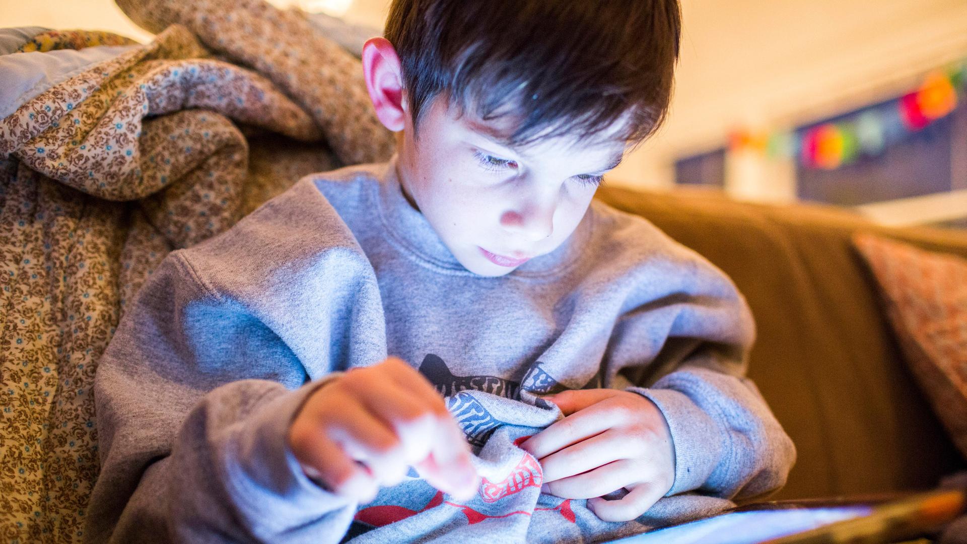 Ein Junge spielt an einem Tablet ein Computerspiele