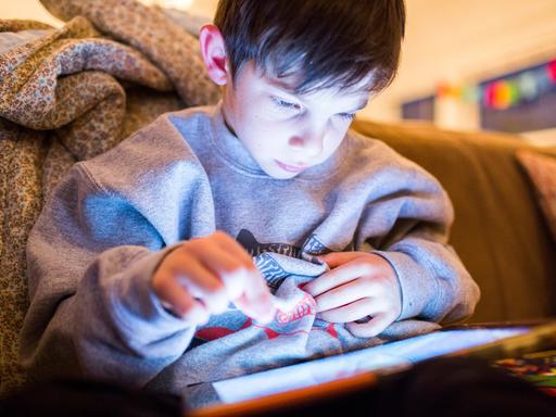 Ein Junge spielt an einem Tablet ein Computerspiele