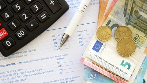 Eine Person füllt Formulare für eine Steuererklärung aus