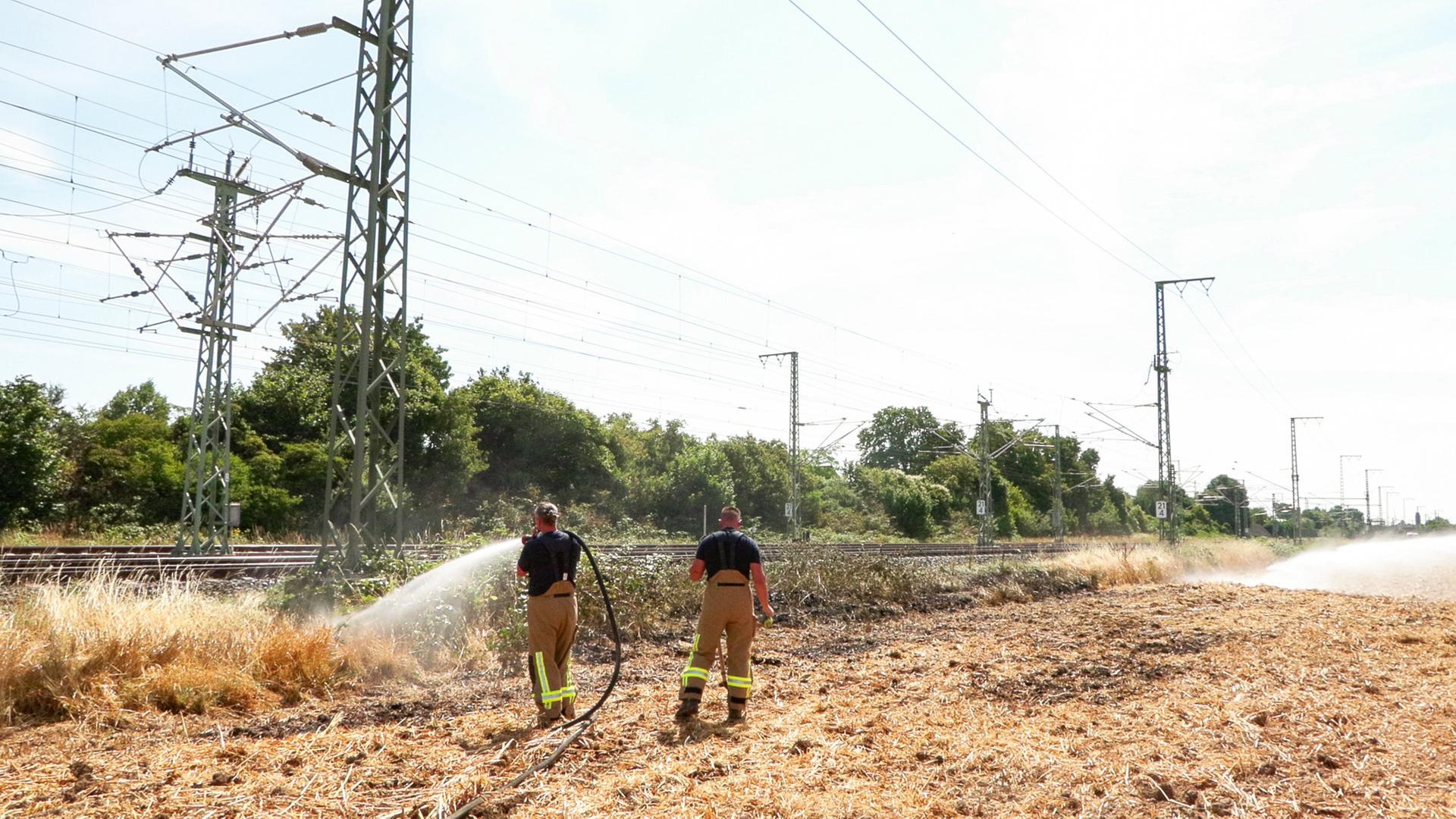 Einsatzkräfte der Feuerwehr löschen einen Böschungsbrand an der wichtigen Bahnstrecke zwischen Düsseldorf und Köln. Einsatzkräfte der Feuerwehr löschen einen Böschungsbrand an der wichtigen Bahnstrecke zwischen Düsseldorf und Köln.