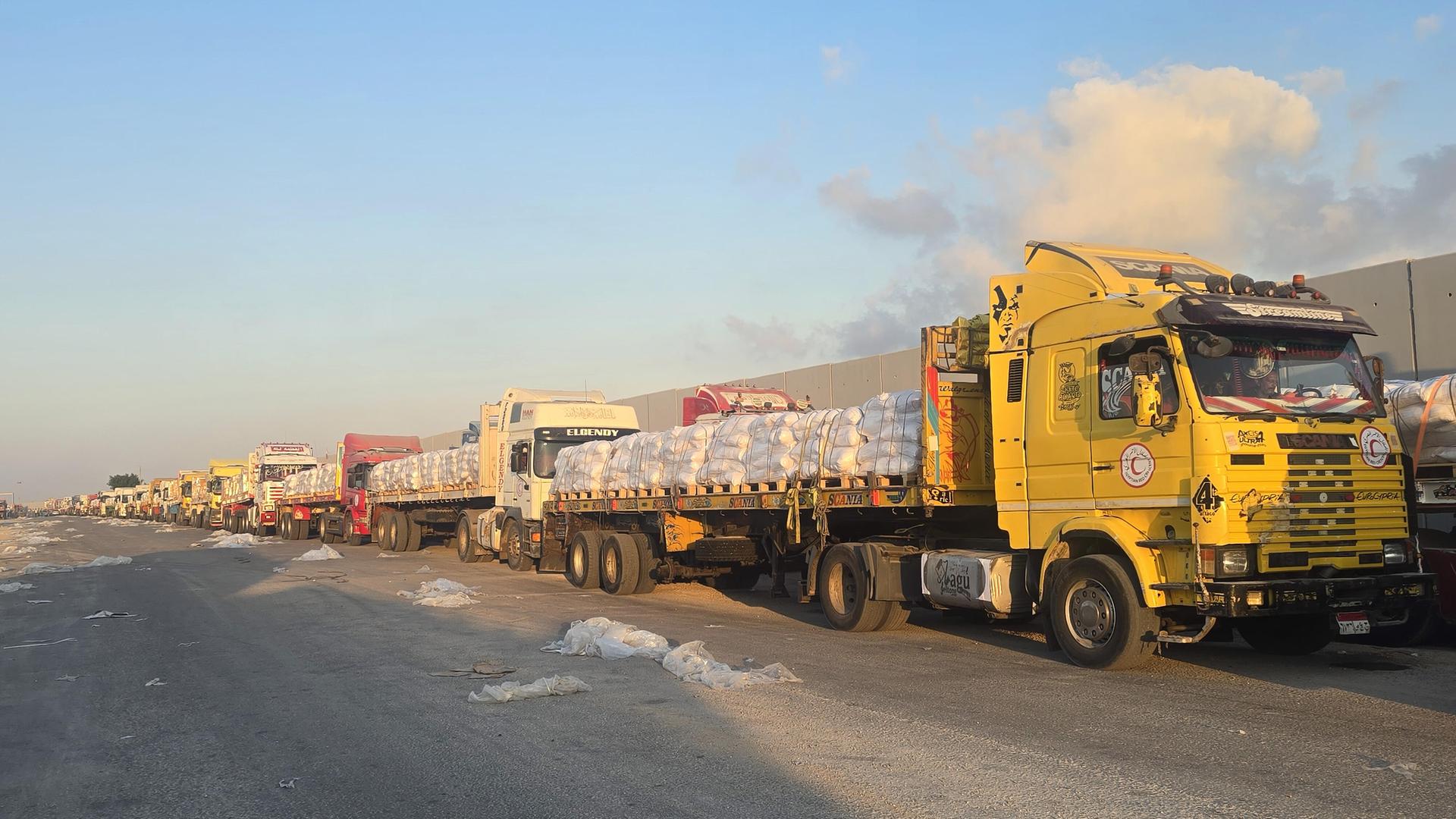 Mehrere Lkw mit Hilfsgütern stehen hintereinander in den Grenzübergang Rafah zwischen Ägypten und dem Gazastreifen.