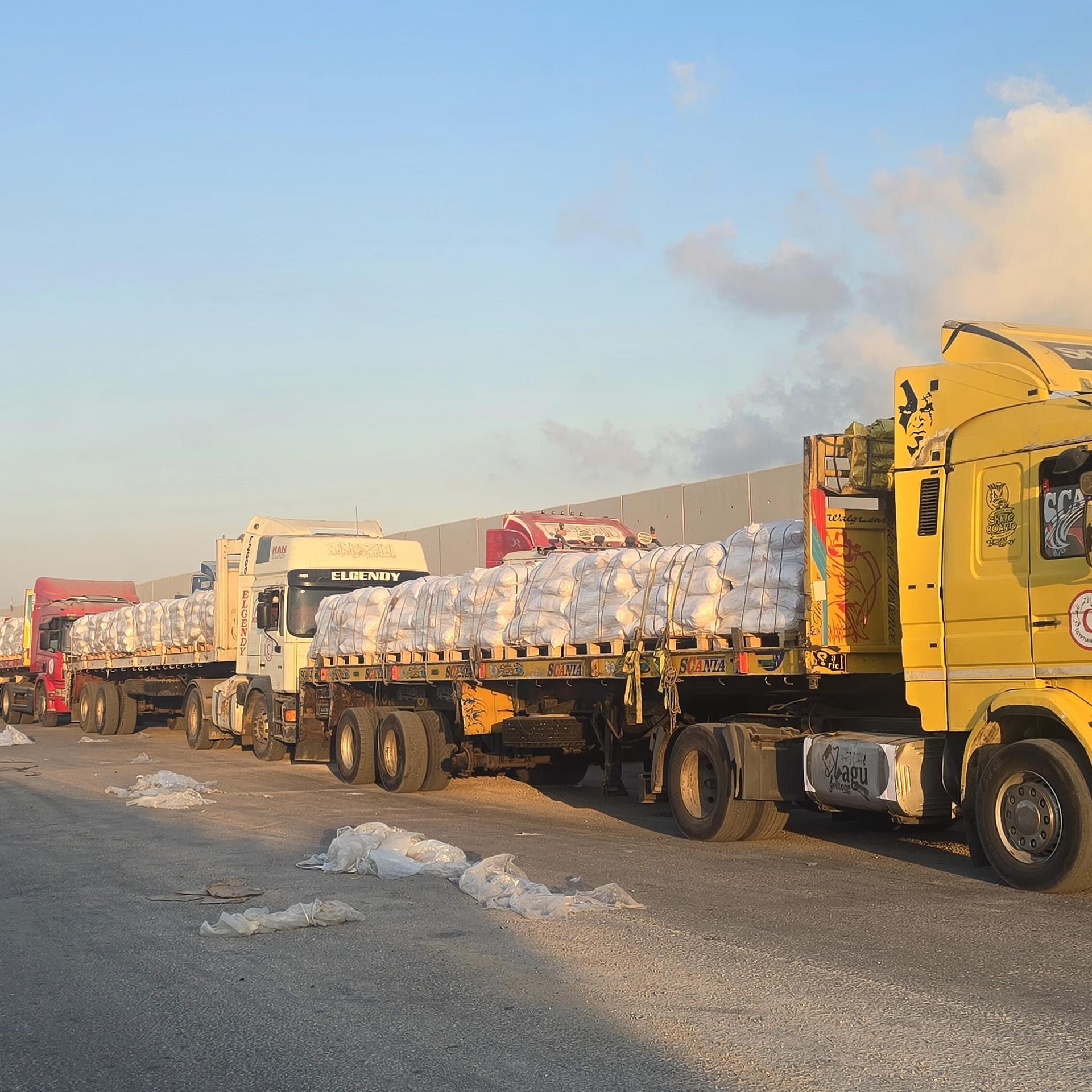Mehrere Lkw mit Hilfsgütern stehen hintereinander in den Grenzübergang Rafah zwischen Ägypten und dem Gazastreifen.