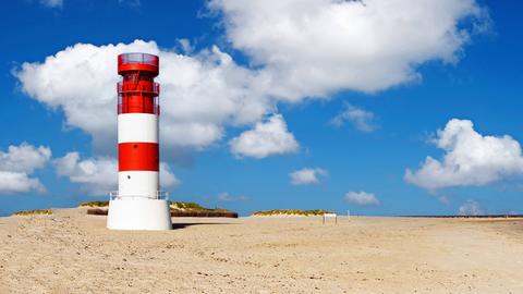 Ein weiß-roter Leuchtturm auf der Helgoland-Düne. 