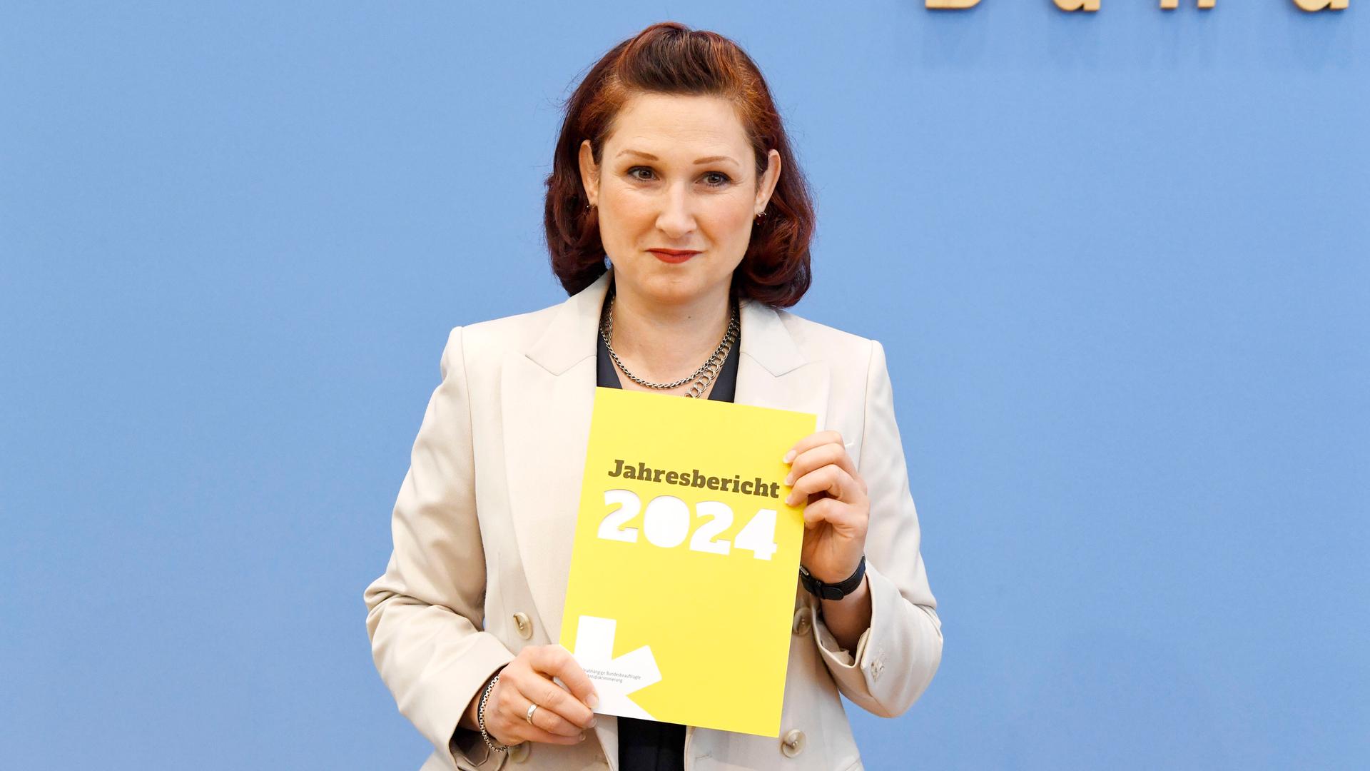 Die unabhängige Antidiskriminierungsbeauftragte des Bundes, Ferda Ataman, hält den Jahresbericht 2024 in die Höhe.