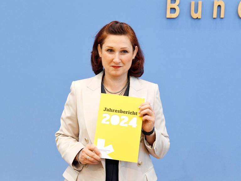 Die unabhängige Antidiskriminierungsbeauftragte des Bundes, Ferda Ataman, hält den Jahresbericht 2024 in die Höhe.