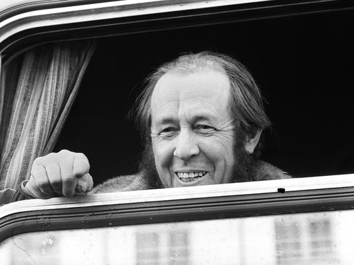 Schwarzweiß Aufnahme von Alexander Solschenizyn, der lächelnd aus dem Fenster eines Zuges schaut