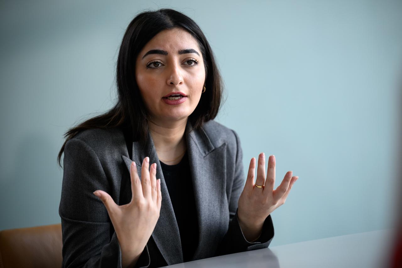 Reem Alabali-Radovan (SPD), Staatsministerin und Beauftragte der Bundesregierung für Migration, Flüchtlinge und Integration, sitzt an einem Tisch und gestikuliert.