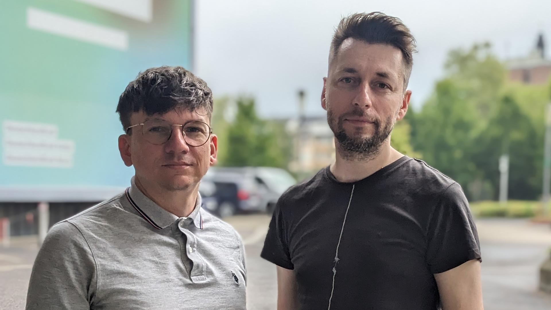 Die Hosts des Podcasts "Ostkinder 80/82" Danny Frede und Alexander Derno stehen vor dem Dlf-Funkhaus in Köln. 