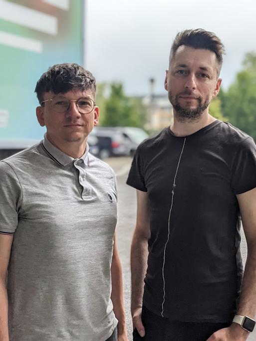 Die Hosts des Podcasts "Ostkinder 80/82" Danny Frede und Alexander Derno stehen vor dem Dlf-Funkhaus in Köln. 