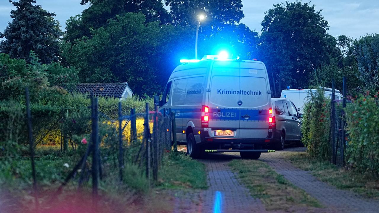 Ein Einsatzfahrzeug der Kriminaltechnik fährt auf einem Weg in einer Kleingartenkolonie in Berlin-Spandau. 