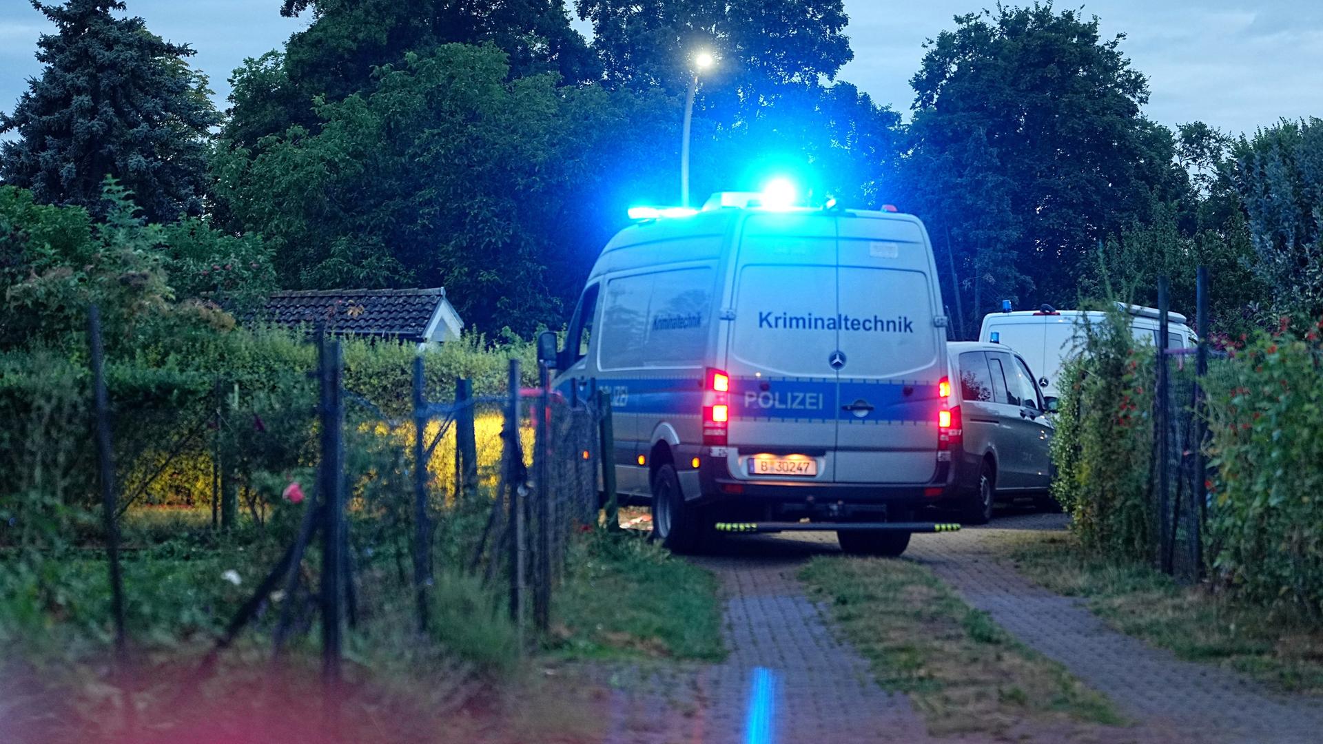 Ein Einsatzfahrzeug der Kriminaltechnik fährt auf einem Weg in einer Kleingartenkolonie in Berlin-Spandau. 