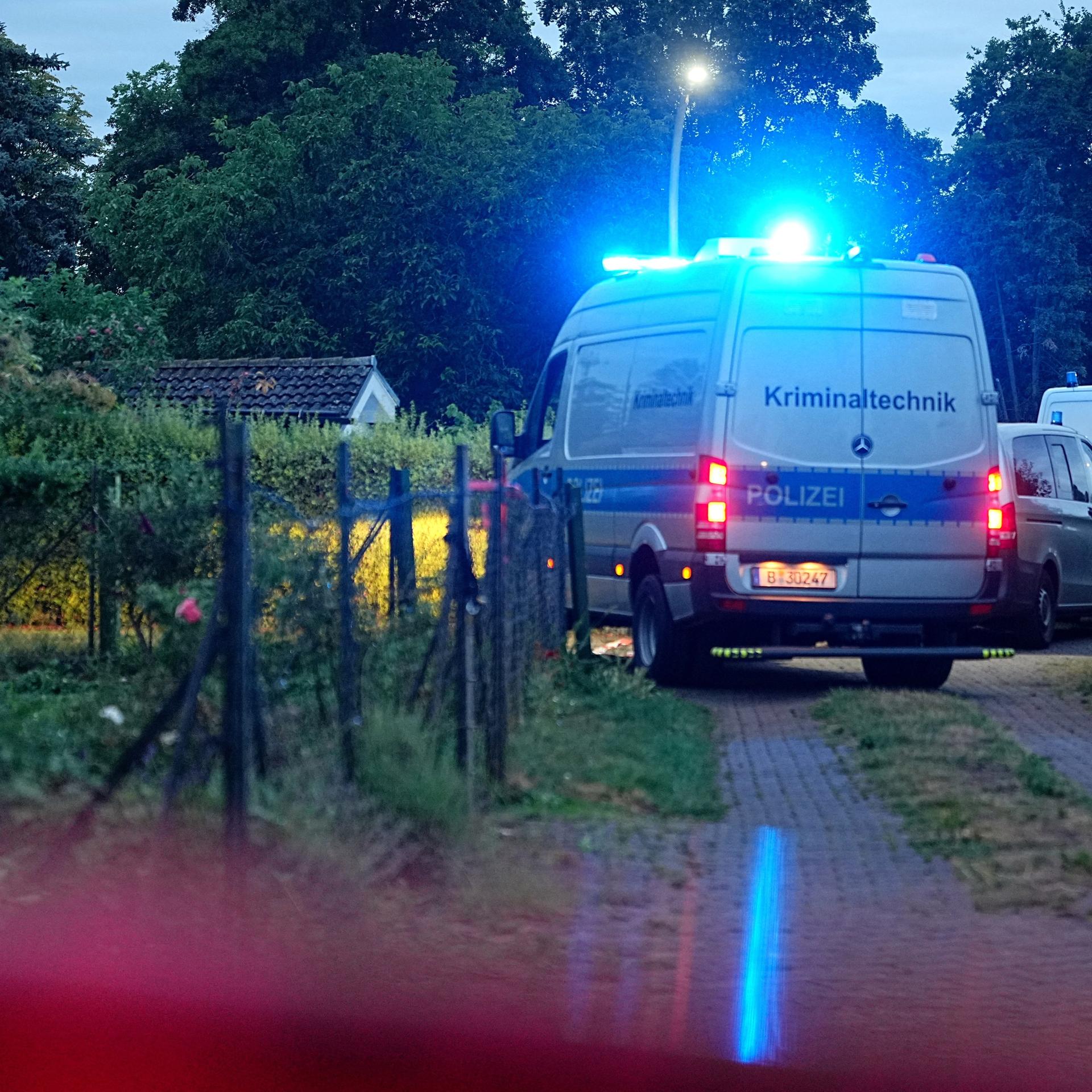 Ein Einsatzfahrzeug der Kriminaltechnik fährt auf einem Weg in einer Kleingartenkolonie in Berlin-Spandau. 