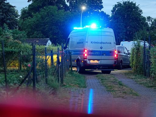 Ein Einsatzfahrzeug der Kriminaltechnik fährt auf einem Weg in einer Kleingartenkolonie in Berlin-Spandau. 