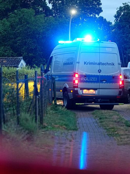 Ein Einsatzfahrzeug der Kriminaltechnik fährt auf einem Weg in einer Kleingartenkolonie in Berlin-Spandau. 