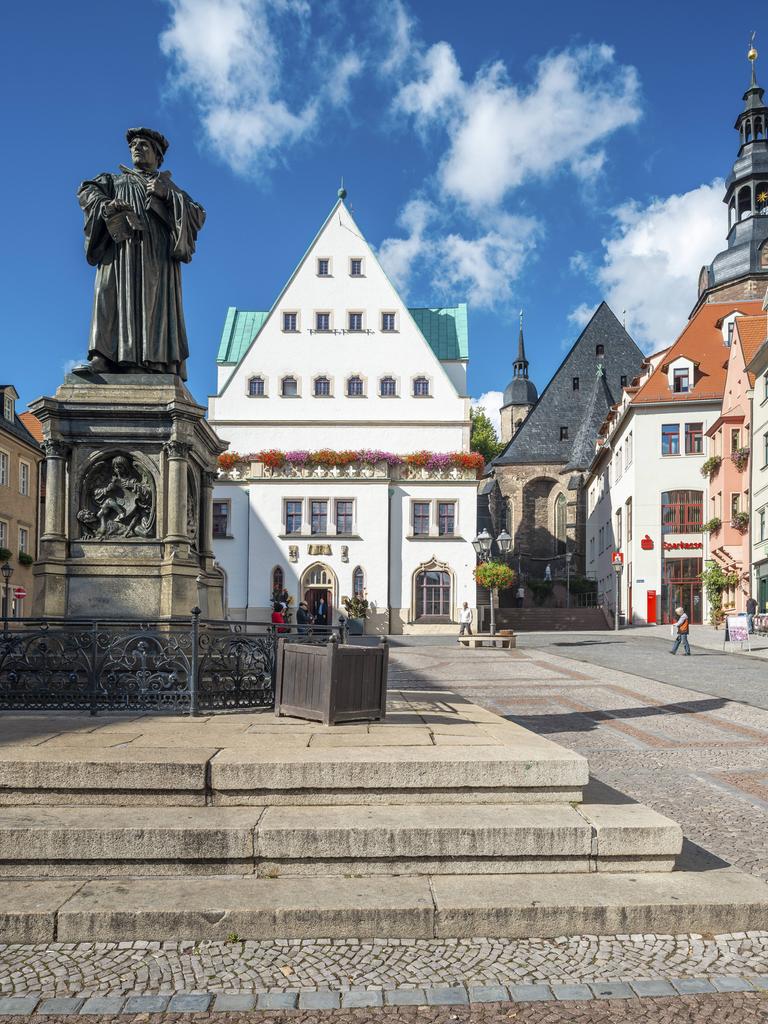 Der Marktplatz von Eisleben mit dem Denkmal für Martin Luther, einer Bronzeplastik von 1883 von Rudolf Siemering, in der Mitte das historische Rathaus, rechts die Andreaskirche
