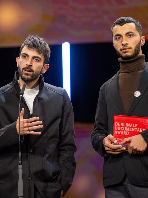 Die Regisseure Yuval Abraham (l) und Basel Adra stehen während der Preisverleihung bei der Abschlussgala im Berlinale Palast auf der Bühne.
