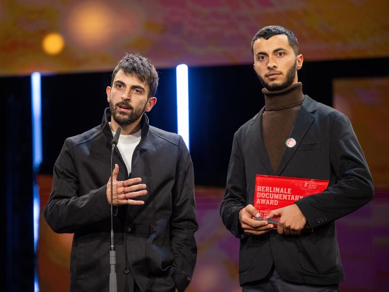 Die Regisseure Yuval Abraham (l) und Basel Adra stehen während der Preisverleihung bei der Abschlussgala im Berlinale Palast auf der Bühne.