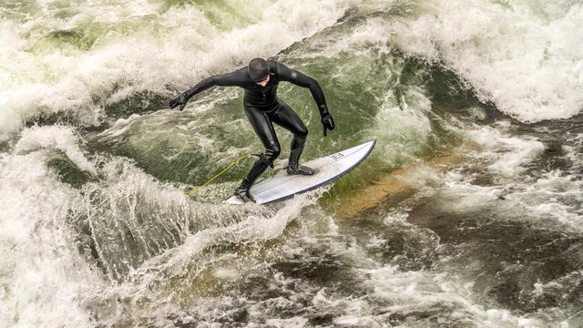 Für kurze Zeit gab es in München wieder eine Eis-Bach-Welle. Surfer hatten dafür ein Brett ins Wasser gehängt. Das Foto zeigt einen Surfer in Aktion.