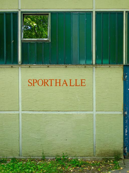 Außenaufnahme eines Gebäudes mit der Aufschrift SPORTHALLE (Symbolbild).