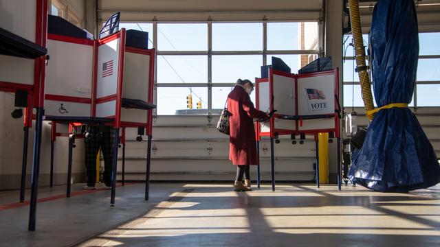 Wählerinnen und Wähler in einem Wahlbüro in Royal Oak, Michigan. Wahlkabinen stehen in einem lichtdurchfluteten Raum.