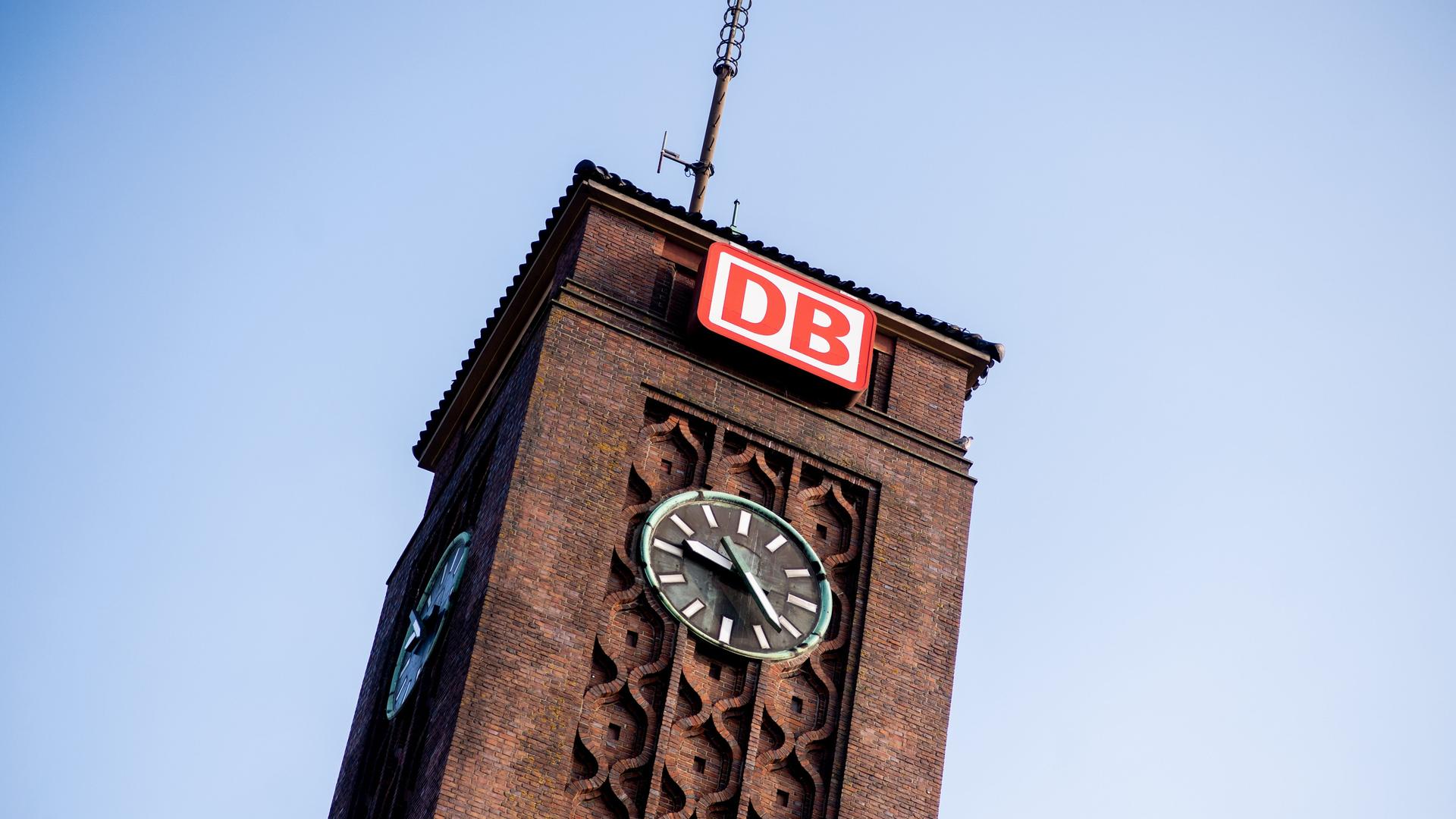 Das Logo der Deutschen Bahn (DB) hängt über einer Uhr am Hauptbahnhof Oldenburg. 