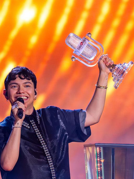 JJ aus Österreich, Gewinner des Eurovision Song Contest, hält während des großen Finales auf der Bühne die Trophäe in der Hand und jubelt.