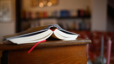 Ein Buch liegt in einem Wohnzimmer auf einem Tisch.